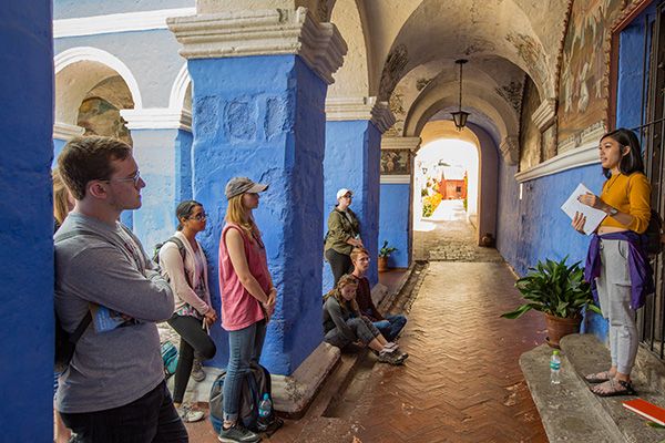 Student presents within a cloister.